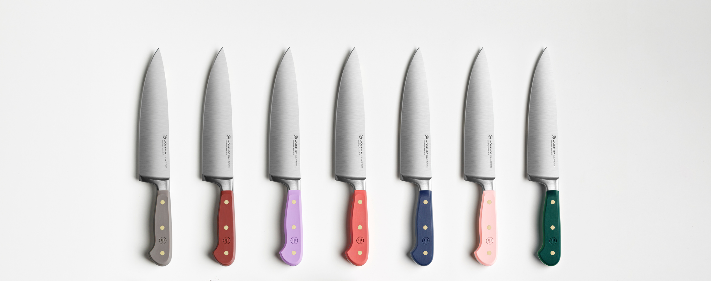 Set of six knives with colored handles on a white background