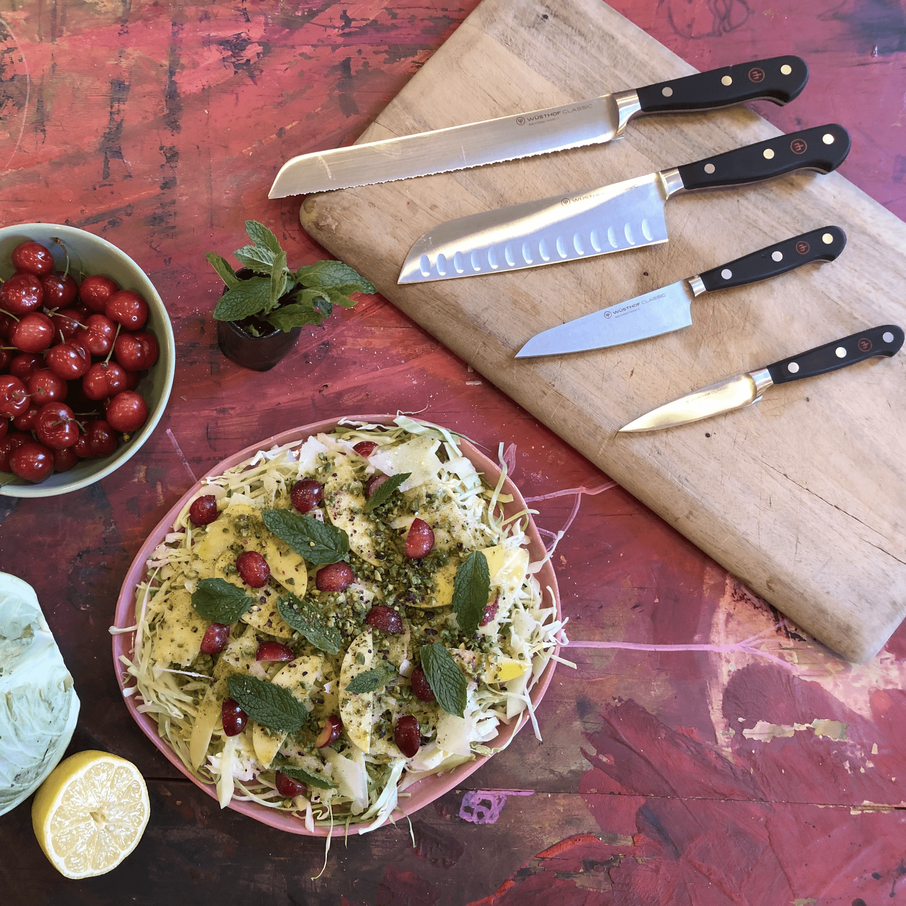 Cabbage salad plated with four WÜSTHOF knives arranged on a cutting board.