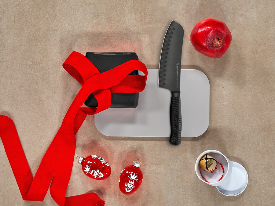 Knife, cutting board, red ribbon, and decorative items on a textured surface